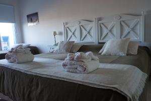 a bedroom with two towels on a large bed at Las Restingas Hotel De Mar in Puerto Pirámides