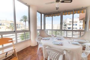 una sala da pranzo con tavolo e alcune finestre di Cozy Beach a El Campello