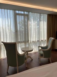 two chairs and a table in front of a window at SOL INVICTUS Boutique Hotel Durres Albania in Durrës