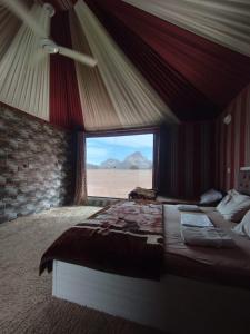 a bedroom with a bed with a view of the desert at Jori Luxury Camp in Wadi Rum