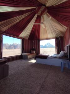 a bedroom with a large tent with a view of the desert at Jori Luxury Camp in Wadi Rum