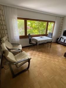 a living room with a table and chairs and windows at Ferienwohnung Urban - AHORN -- Meersburg in Meersburg