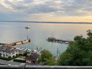 uma grande massa de água com uma doca e um barco em Ferienwohnung Urban - AHORN -- Meersburg em Meersburg