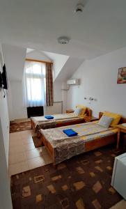 a room with three beds in it with a window at Pensiunea Mikelis International in Curtea de Argeş