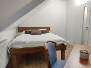 - une chambre avec un lit et une chaise bleue dans l'établissement Penzion Na Protivínské, à Strakonice