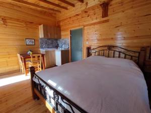 een slaapkamer met een bed in een blokhut bij Ovadi Valley Houses in Urgup