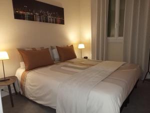 a large white bed in a room with two lamps at Pour une agréable pause au Parc ! in Alençon