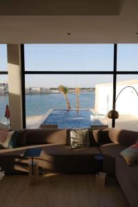 sala de estar con sofá y piscina en Elite Resort - Private Pool & Beach, en Bahía de la Media Luna