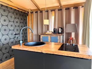 una cocina con fregadero en una casa pequeña en Glamping - Il Giardino di San Giorgio, en Montorgiali