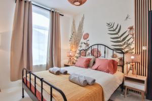 1 dormitorio con 1 cama grande con almohadas rosas en Logement hypercentre de Spa, en Spa