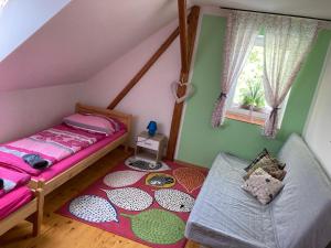 a attic bedroom with a bed and a rug at Apartmány Lucie in Karlovice