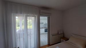 a bedroom with a bed and a sliding glass door at Karmen in Kampor