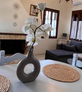 a black vase with white flowers in it on a table at Margianou Apartments in Kalamos