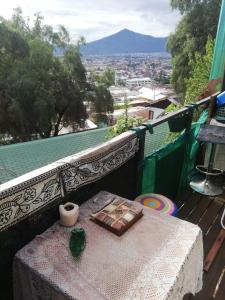 a table with a book on a balcony with a view at Quiet cottage in a hill with great view not far to downtown in Santiago