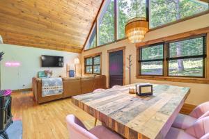 uma sala de estar com uma grande mesa de madeira e cadeiras em Pet-Friendly Lackawaxen Cabin with Wraparound Deck! em Lackawaxen