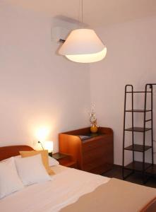 1 dormitorio con cama, lámpara y cómoda en Apartman Maslina, en Šibenik