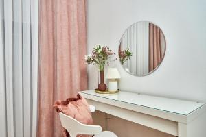 une coiffeuse avec un miroir et une chaise dans l'établissement Стильні Апартаменти на Ратушній площі, à Moukatcheve