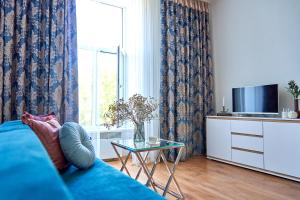 - un salon avec un canapé bleu et une fenêtre dans l'établissement Стильні Апартаменти на Ратушній площі, à Moukatcheve