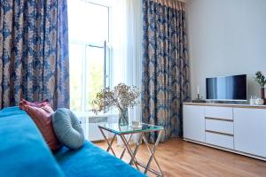 a living room with a blue couch and a window at Стильні Апартаменти на Ратушній площі in Mukacheve +36 photos