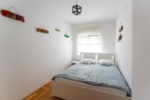 a bedroom with a bed in a white room at Apartman Borik in Bjelovar