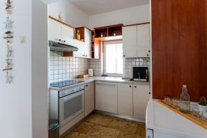 a small kitchen with white cabinets and a window at Apartment Borik in Bjelovar