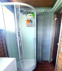 a shower with a glass door in a bathroom at Villa Mummola Neljän makuuhuoneen asunto lähellä jokea in Simpele