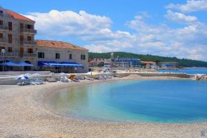 a resort with a large pool of water on a beach at Apartment Ranka in Postira