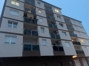 a tall apartment building with windows at Stan na dan Foca in Foča