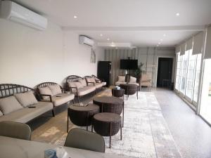 a living room with couches and tables and a television at مزرعة واستراحة المنامة 