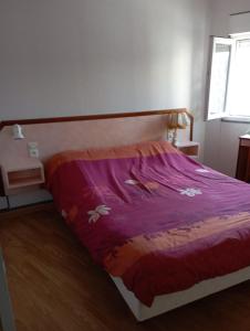 ein Schlafzimmer mit einem Bett mit einer lila Bettdecke in der Unterkunft Saint Pair sur Mer 50 m de la plage in Saint-Pair-sur-Mer
