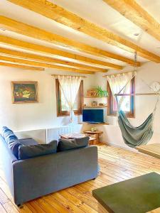 a living room with a couch and a hammock at Meublé de la Doller - Chalet au bord de l’eau in Masevaux