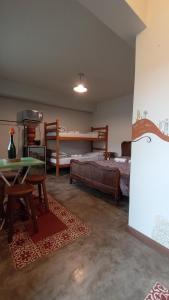 un soggiorno con letto, tavolo e comodino. di - Casa Pitanga - Acomodação lindíssima pertinho da Igreja do Rosário a Ouro Preto