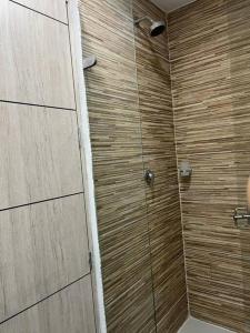 a bathroom with a shower with a wooden wall at living ventto calle 18 in Bogotá