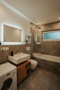 a bathroom with a sink and a washing machine at WITTMANN Ganze Apartments in Gifhorn in Gifhorn +37 photos