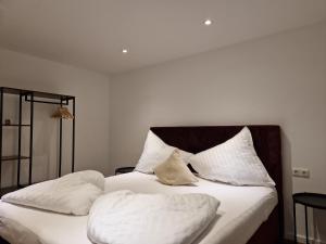 Apartment Ramazotti في باد هوفغاستين: غرفة نوم بسرير ذو شراشف ووسائد بيضاء