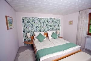 a bedroom with a large bed with green pillows at Ferienwohnung Deubzer in Palling in Palling