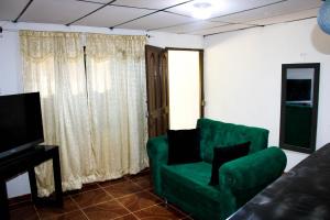 un salon avec un canapé vert et une télévision dans l'établissement Apartamento a unos pasos de la playa, à Carthagène des Indes