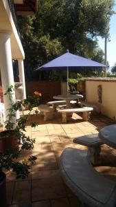 een patio met tafels en een blauwe parasol bij Harties Lodge - Meerhof Bay View 6 in Hartbeespoort