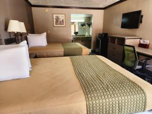 um quarto de hotel com duas camas e uma secretária em Executive inn em Oklahoma City