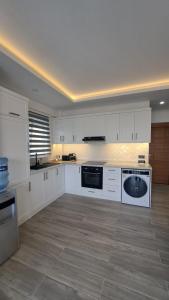 a large kitchen with white cabinets and appliances at Belek King Cleodora Apartment in Belek