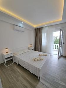 a white bedroom with a large bed and a window at Belek King Cleodora Apartment in Belek