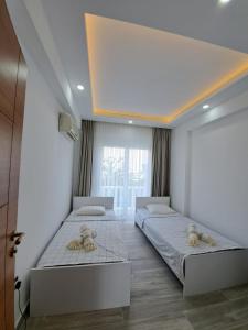 a bedroom with two beds and a large window at Belek King Cleodora Apartment in Belek
