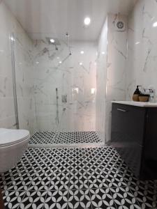 een witte badkamer met een zwart-witte tegelvloer bij Belek King Cleodora Apartment in Belek