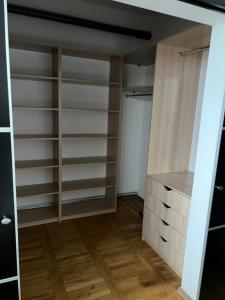 a closet with wooden shelves and a wooden floor at Apartamenty Dekora in Żary