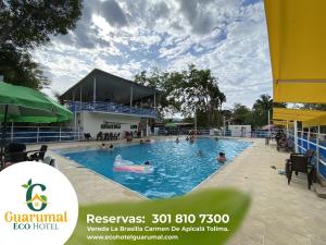 a swimming pool at a resort with people in it at Eco Hotel Guarumal in Carmen de Apicalá