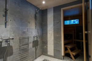 een badkamer met een inloopdouche en een bank bij Log-house at Pyhätunturi ski resort. in Pyhätunturi