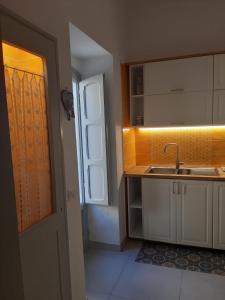 eine Küche mit einem Waschbecken, einem Fenster und einer Tür in der Unterkunft Rifugio di Sibir in Selva di Fasano