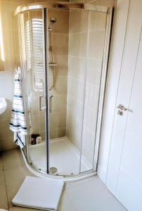 La salle de bains est pourvue d'une douche avec une porte en verre. dans l'établissement Private Room, à Lucan