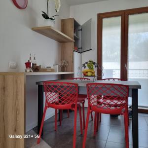 a kitchen with a table and two red chairs at Ca' Massima, il cuore a Monza in Lissone