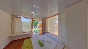 Habitación pequeña con cama y ventana en Eco Hotel Guarumal, en Carmen de Apicalá